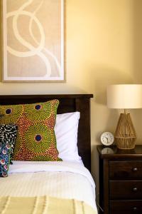 ein Schlafzimmer mit einem Bett und einer Uhr auf einem Nachttisch in der Unterkunft Marcotta Guest Suite - Moments to Golf Course in Orange