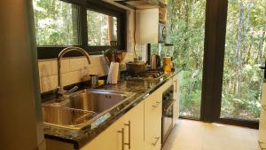 a kitchen with a sink and a large window at Cabaña Bosque Rio in Puerto Varas
