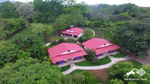una vista aérea de una casa con techos rosados en Los Susurros. Casa, en Palenque