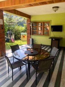 a patio with a table and chairs on a porch at Rancho Ecoturistico Grevillea 