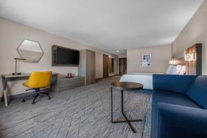 a hotel room with a bed and a yellow chair at Holiday Inn Express San Diego - Sorrento Valley by IHG in Sorrento