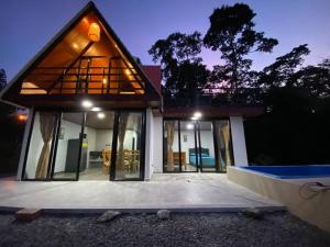 a house with a large window on the front of it at Hermosa Cabaña cerca a Villeta in Quebradanegra