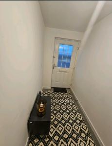 ein Flur mit einem schwarzen Tisch und einer Tür in der Unterkunft Darnley southside room in a private home 61 Leggastston Road in Pollokshaws
