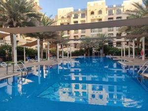 a large swimming pool in front of a building at 1Bedroom Luxury Apartment By Mamzar Beach in Dubai