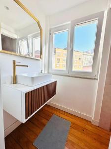 - une salle de bains blanche avec lavabo et 2 fenêtres dans l'établissement Lisbon City Center flat for 6 pp, à Lisbonne