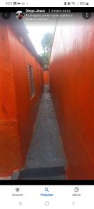 ein Bild einer orangenen Wand mit einem Flur in der Unterkunft Recanto Simões in Itariri