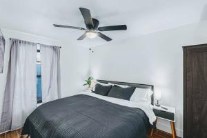 鳳凰城的住宿－Phoenix Retreat - 2 Bedroom Home with King-Size Bed - 3 Smart TVs - 10 min from Airp - Unit A，一间卧室配有一张带吊扇的床