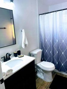 y baño con aseo, lavabo y ducha. en Phoenix Retreat - 2 Bedroom Home with King-Size Bed - 3 Smart TVs - 10 min from Airp - Unit A, en Phoenix