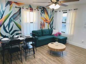 a living room with a green couch and a table at Phoenix Retreat - 2 Bedroom Home with King-Size Bed - 3 Smart TVs - 10 min from Airp - Unit A in Phoenix