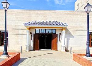 ein großes Backsteingebäude mit einer großen Tür in der Unterkunft Hotel Puerto de Palos (La Rabida) in Palos de la Frontera