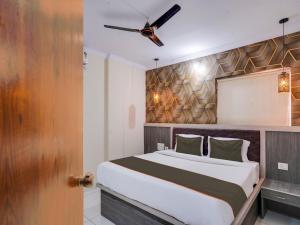 a bedroom with a bed and a ceiling fan at Super Collection O Hotel Blue Petals in Shamshabad