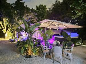 a table with chairs and an umbrella at night at Jacuzzi•Glamping•Gym•Parking•BBQ•Soft Beds•Secure in Miami