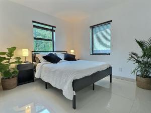 a bedroom with a bed and two potted plants at Jacuzzi•Glamping•Gym•Parking•BBQ•Soft Beds•Secure in Miami