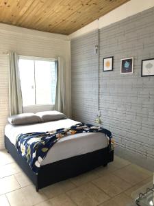 a bedroom with a large bed with a window at Hospedaria Mirante da maré ap2 in Imbituba