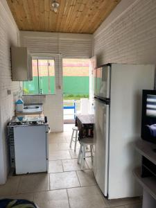 a kitchen with a refrigerator and a table at Hospedaria Mirante da maré ap2 in Imbituba