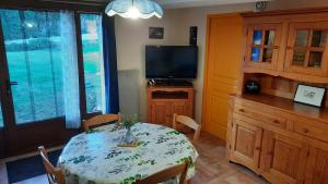a dining room with a table and a television at La petite maison dans la prairie in Cassaignes