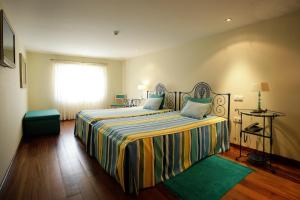 um quarto com uma cama grande e uma janela em Casa Dos Poos em Vilar Torpim