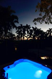 una bañera de hidromasaje azul por la noche con palmeras en LALDEA Nirvana Eco Villa in Cerritos, en Pereira