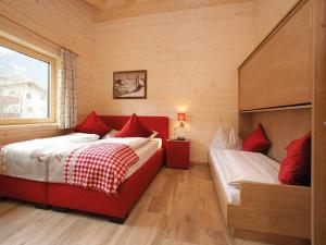 sypialnia z 2 łóżkami i białymi i czerwonymi poduszkami w obiekcie Kaprun Lodge - R w Kaprunie