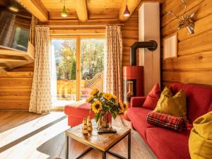 a living room with a red couch and a fireplace at Nature Lodge Kaprun B in Kaprun