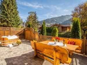 a patio with a wooden table and a bench at Nature Lodge Kaprun B in Kaprun