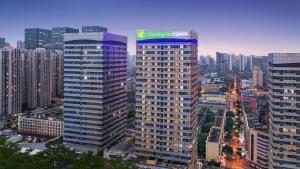 成都市にあるHoliday Inn Express Chengdu North Railway Station, an IHG Hotelの標識のある高層ビル