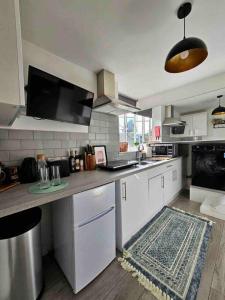 een keuken met witte kasten en een aanrecht bij Stylish Putney village flat in Londen