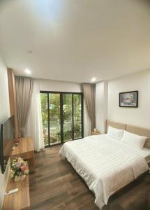 a bedroom with a large white bed and a television at Studio-Vincent Apartment HaNoi in Hanoi