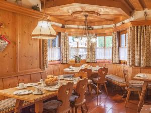 een eetkamer met een tafel, stoelen en ramen bij Pension Blaiken XL in Scheffau am Wilden Kaiser