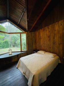 1 dormitorio con 1 cama grande en una habitación con ventana en Cabaña Los acantilados en Mar del Plata