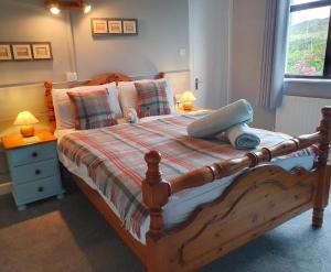 a bedroom with a large wooden bed with two lamps at The Ramblers Rest B&B in Doolin