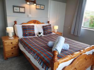 a bedroom with a bed with a teddy bear on it at The Ramblers Rest B&B in Doolin