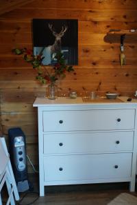 a white dresser with a vase on top of it at Kleine Blockhütte im Garten 