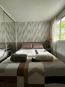 a bedroom with a large bed with two pillows on it at Apartamento GolfVille Residence in Aquiraz
