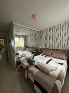 a bedroom with two beds and a mirror at Apartamento GolfVille Residence in Aquiraz