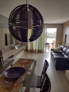 kuchnia i salon ze szklanym stołem i żyrandolem w obiekcie Apartamento GolfVille Residence w mieście Aquiraz