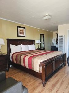 a bedroom with a large bed and two lamps at Parkway Motel & European Lodges in Pincher Creek