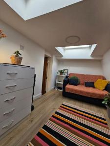 a living room with a couch and a dresser at West Kensington bright flat in London