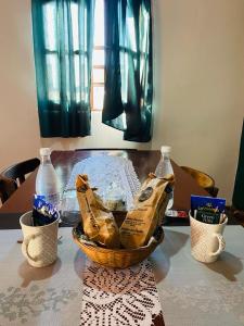 een tafel met een mand met eten en flessen erop bij Sueño de Chicoana in Chicoana