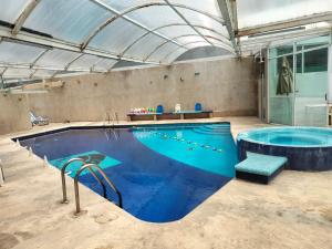einem großen Pool mit Whirlpool in einem Gebäude in der Unterkunft San Marino grupos familiares o amigos in San Francisco Tlalnepantla