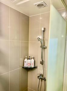 a bathroom with three shampoo bottles on a shelf at Lime hotel in Suwon