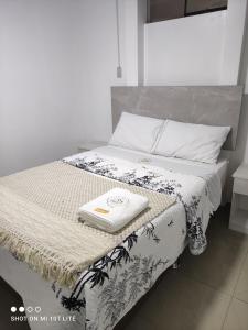 Una cama con una toalla encima. en Hostal Qhasi Kay en Huancayo