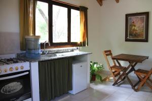 cocina con fregadero, fogones y ventana en Cabañas Bhakti Dham, hospedaje vegetariano en San Esteban