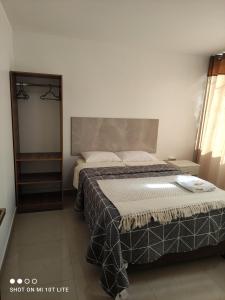 1 dormitorio con cama y espejo en Hostal Qhasi Kay en Huancayo