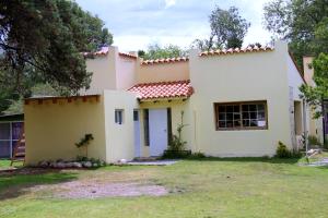 una gran casa blanca con patio en Cabañas Bhakti Dham, hospedaje vegetariano en San Esteban