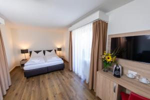 Un pat sau paturi într-o cameră la Hotel Alexander