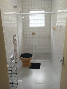La salle de bains est pourvue de toilettes et d'une fenêtre. dans l'établissement Casa Harmonia, à Guarujá