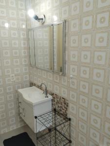 La salle de bains est pourvue d'un lavabo et d'un miroir. dans l'établissement Casa Harmonia, à Guarujá