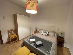 1 dormitorio con 1 cama grande y 1 silla amarilla en Apartamento cuco Finestrat, en Finestrat