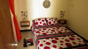 um quarto com uma cama com um cobertor vermelho e branco em COMODO Y TRANQUILO ! EN ARMENIA QUINDIO em Armênia